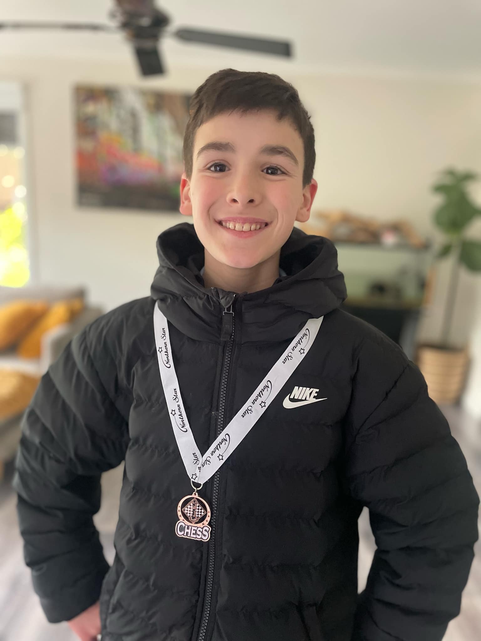 A young Oz Chess Kids student with a competition medal
